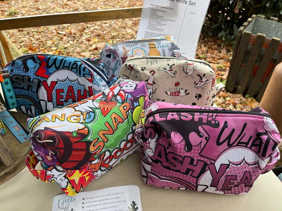 Verschiedene bunte Kosmetiktaschen mit grafischen Mustern und Sprüchen.