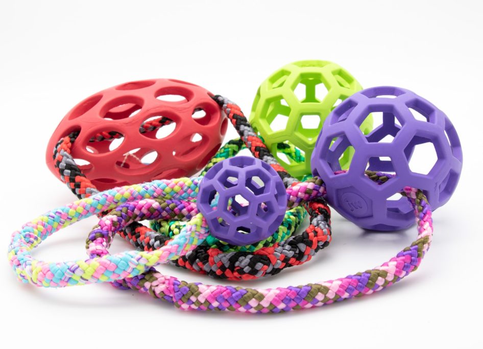 Bunte Spielzeuge und Bälle aus Gummi und Seil in verschiedenen Formen und Größen.