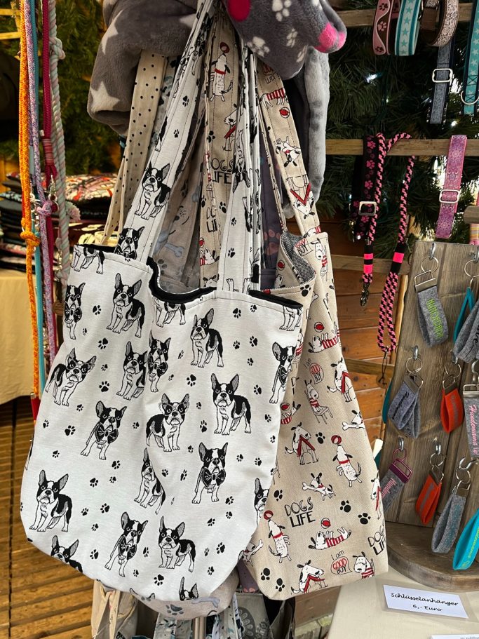 Mehrere Stoffbeutel mit verschiedenen Mustern hängen an einem Ständer.